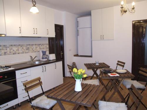 布拉索夫Blue House的厨房配有白色橱柜和桌椅