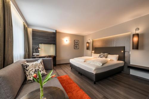 慕尼黑桑提斯酒店的酒店客房,配有床和沙发