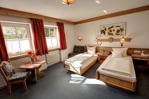 莫斯堡胡贝尔酒店的一间卧室配有两张床和一张桌子及椅子