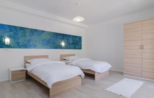 普洛切Apartmani Monaco的卧室内的两张床,墙上有绘画作品