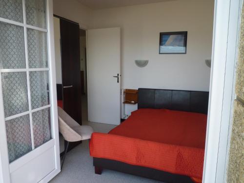 卡纳克Mouettes 2 - Carnac的卧室配有红色的床和门