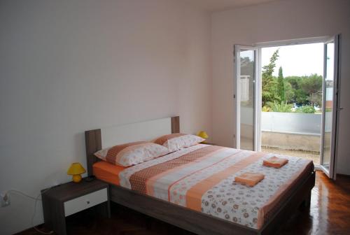 VerunićAnte Carov Apartment的一间卧室设有一张床和一个滑动玻璃门