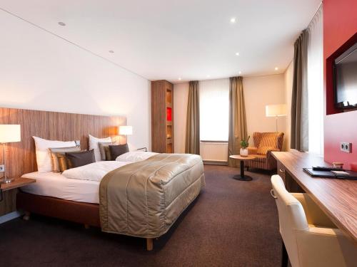 芬洛瓦鲁亚斯酒店的酒店客房设有一张大床和一张书桌。