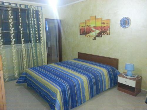 CollepassoB&B La Collina的一间卧室配有一张带蓝色和黄色条纹毯子的床
