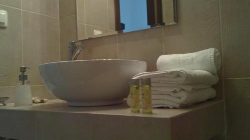 卡斯托里亚戴尔拉戈别墅精品酒店的一间带碗水槽和台面毛巾的浴室