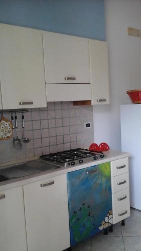 切萨雷奥港Appartamenti Colle Azzurro的厨房配有白色橱柜和炉灶烤箱。