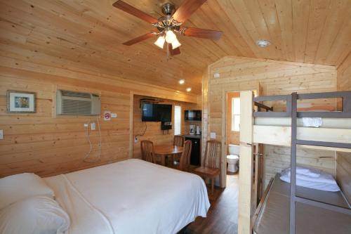 WillisLake Conroe Queen Studio Cabin 5的一间卧室配有一张床和吊扇
