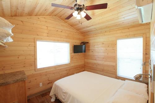 WillisLake Conroe Two-Bedroom Cabin 13的一间卧室配有一张床和吊扇