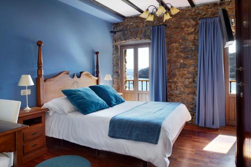 吉塔里亚卡塔伯纳旅馆的一间卧室拥有蓝色的墙壁,配有一张带蓝色枕头的床。