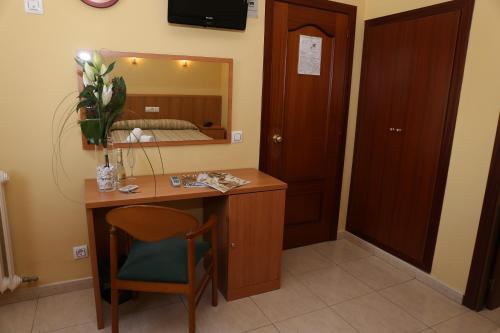 菲格拉斯菲格拉斯欧罗帕酒店的客房设有书桌、镜子和床。