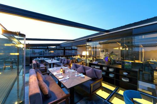 伊斯坦布尔加拉塔沃尔顿酒店的阳台餐厅配有桌椅