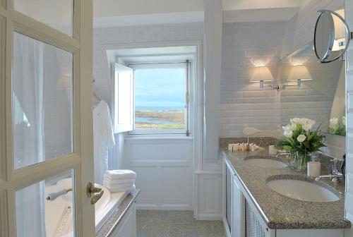 勒克鲁西克海洋堡垒酒店的一间带两个盥洗盆和窗户的浴室