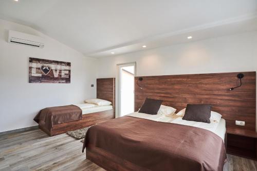 乌马格Apartments Tre Perle的一间卧室设有两张床和木墙