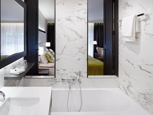 瓦尔斯凡德瓦克酒店的带浴缸、水槽和镜子的浴室
