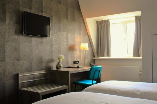 哈默伦哈姆伦瓦品酒店的酒店客房配有一张床、一张书桌和一台电视。