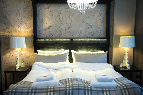 托尔尼奥奥洛夫酒店的一间卧室配有一张带白色床单和两盏灯的床。