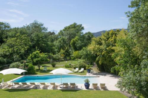 格里莫Hotel Le Verger Maelvi的游泳池的形象,游泳池的椅子和树木
