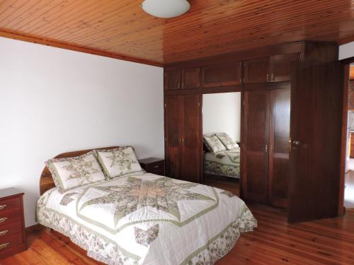圣罗克杜皮库Casas da Carlota的一间卧室设有一张床和木制天花板
