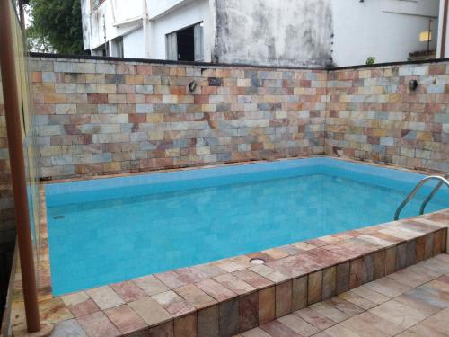 马里亚纳Pousada do Chafariz的一座带砖墙的游泳池