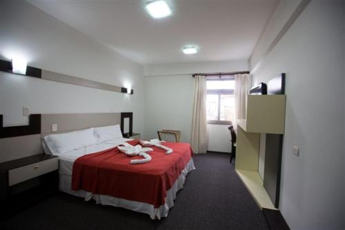 圣拉斐尔纽沃门多酒店的酒店客房,配有红色的床单和毛巾