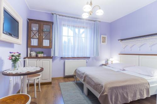 卡齐米日-多尔尼格勒科奇旅馆的一间卧室配有两张床、一张桌子和一台电视。