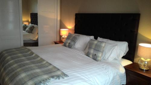 奥尼赫Allt Nan Ros Apartments fort william的卧室配有一张带白色床单和枕头的大床。