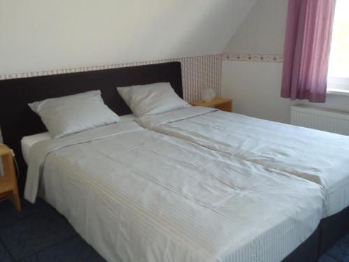 BattenoordHuize Polderzicht aan het Grevelingenmeer的一间卧室配有一张带白色床单的大床