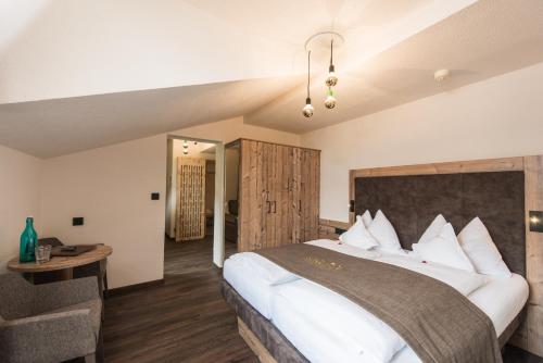 卡迪皮特拉MOUNTAIN ALPIN Hotel Sonnleiten的卧室配有一张白色的大床和一张桌子