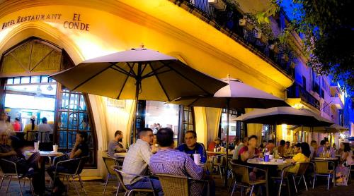 圣多明各佩纳巴康德酒店的坐在餐厅桌子旁,拿着雨伞的人