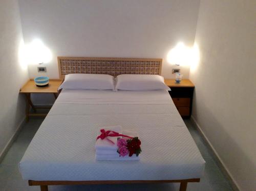 马里迪莫Dimora Tipica Vista Mare的卧室配有白色的床,上面有花束