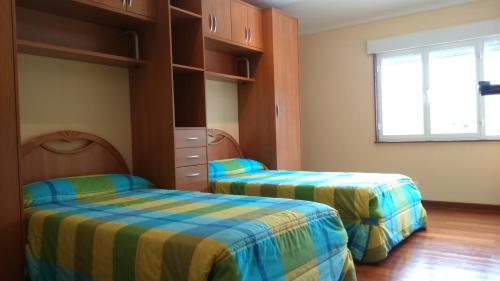 卡尔诺塔Apartamento Peralbar的一间卧室设有两张床和窗户。