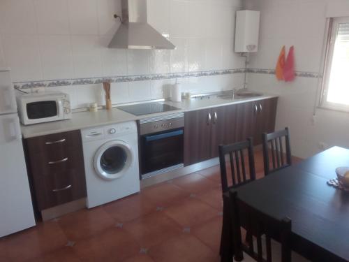 卡尔诺塔Apartamento Peralbar的厨房配有洗衣机和微波炉。