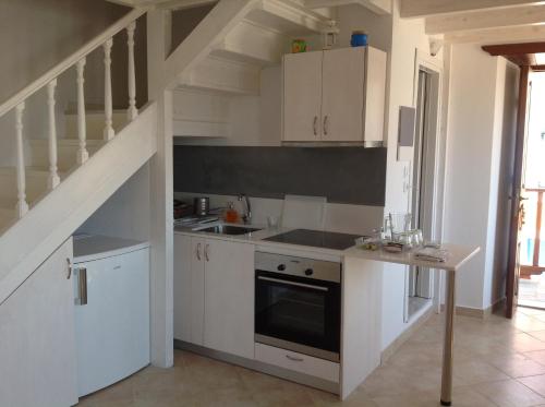 哈尔基岛Amalia Harbor的一间厨房,配有白色橱柜和楼梯