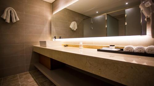 晋州市J广场婚庆酒店的浴室配有盥洗盆、镜子和毛巾