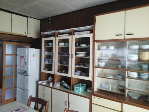 富士宫市面对面旅馆的厨房配有白色橱柜和白色冰箱。