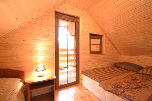 普斯科沃Mała Frajda的小木屋内一间卧室,配有一张床和一个窗户