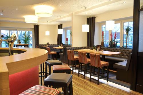 TwistHotel Drei Linden的一间带桌椅的餐厅和一间酒吧
