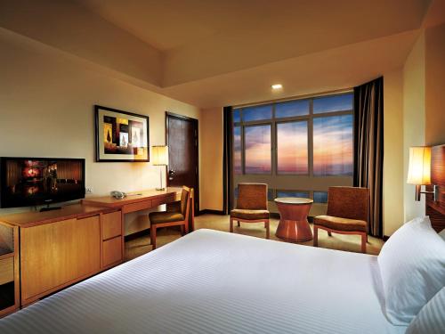 云顶高原云顶名胜世界 - 度假酒店的酒店客房配有一张床、一张书桌和一台电视。