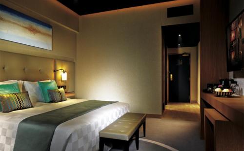 云顶高原Resorts World Genting - Highlands Hotel的酒店客房设有一张大床和长凳。