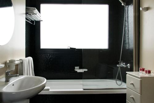 布宜诺斯艾利斯Épico Recoleta Hotel的浴室配有盥洗盆、浴缸和盥洗盆