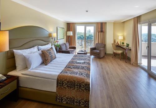 古雷Ramada Resort Kazdağlari Thermal & Spa的酒店客房设有一张大床和一张书桌。
