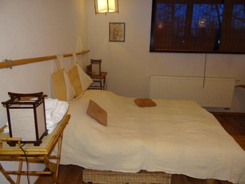布雷亚扎潘吉尼竹园 - 别墅的卧室配有一张白色大床和一把椅子