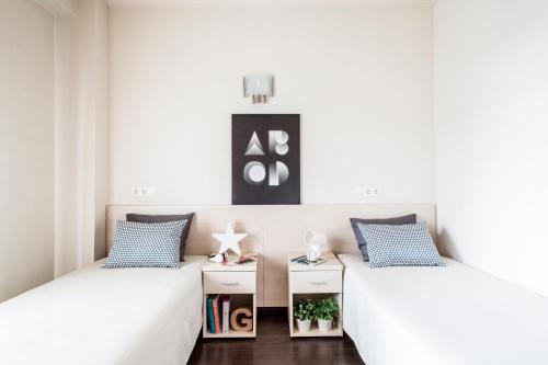 阿尔卡拉德荷那利斯希内尔德洛斯里奥斯大学公寓旅舍的白色墙壁客房的两张床