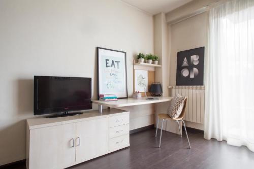 阿尔卡拉德荷那利斯希内尔德洛斯里奥斯大学公寓旅舍的客厅配有白色橱柜上的平面电视
