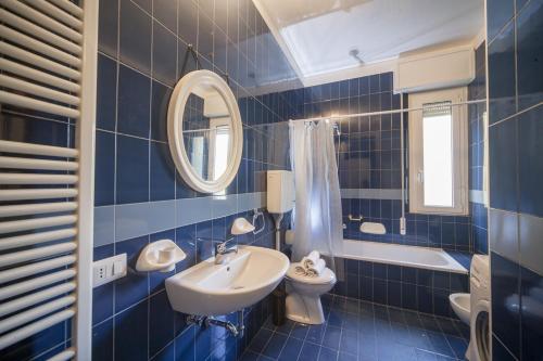 里乔内科伦坡酒店的蓝色瓷砖浴室设有水槽和卫生间