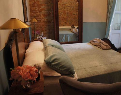 阿尔巴卡萨德拉托雷酒店的一间卧室配有两张床和镜子