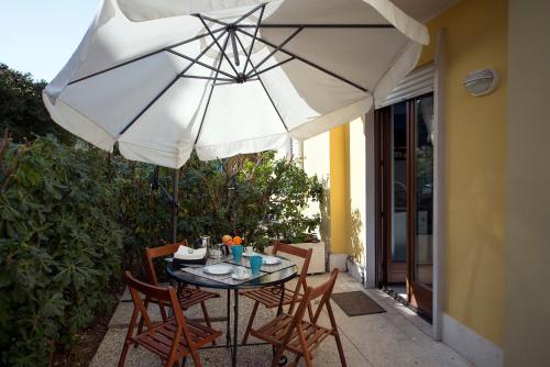 阿科Casa Vacanze RE.TI.的露台的遮阳伞下的桌椅