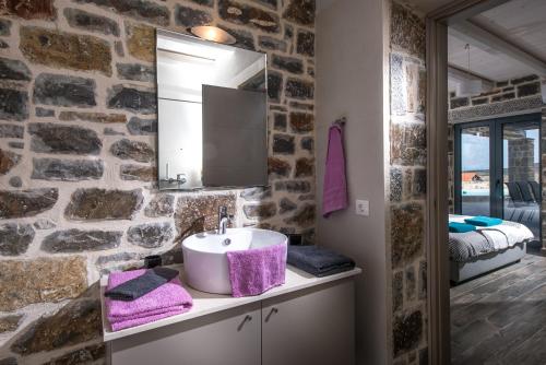 库基尼坎尼奥Anna Luxury Villa Cretevasion的一间带水槽和石墙的浴室
