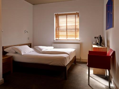 莱斯特奇妮酒店的一间小卧室,配有床和窗户