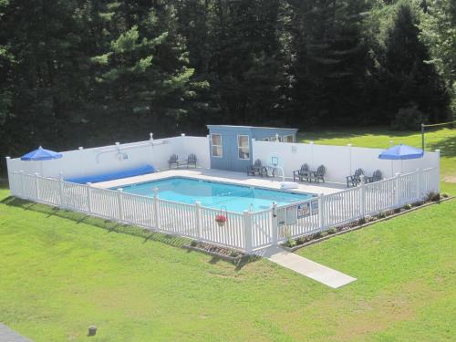 巴特利特北美殖民地汽车旅馆和小屋的一座大型游泳池四周环绕着白色围栏